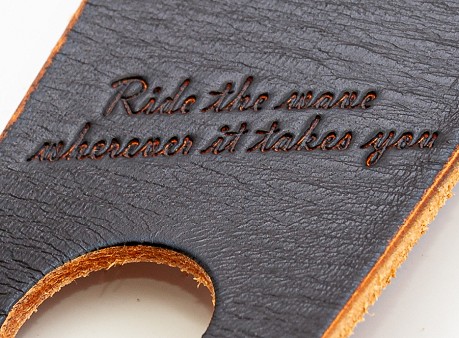 Detalle del diseño grabado en piel de la correa RightOn! Legend E.V. con texto “Ride the wave wherever it takes you”